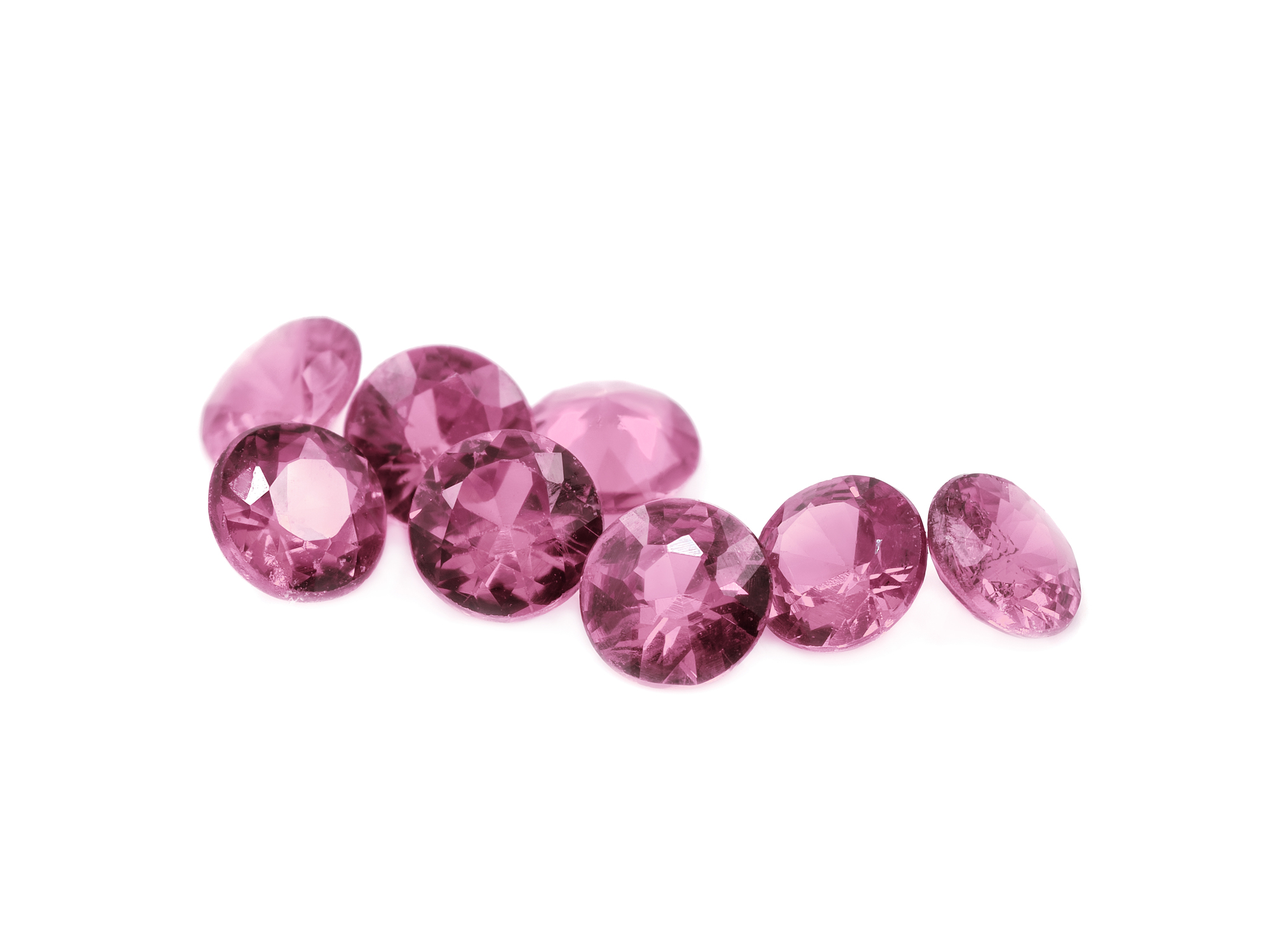 Pink tourmaline diamond cut gems on a white background.
